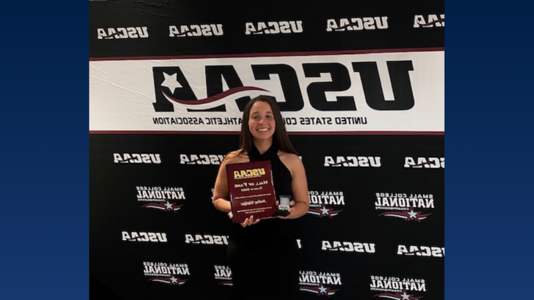 A college student holding an award